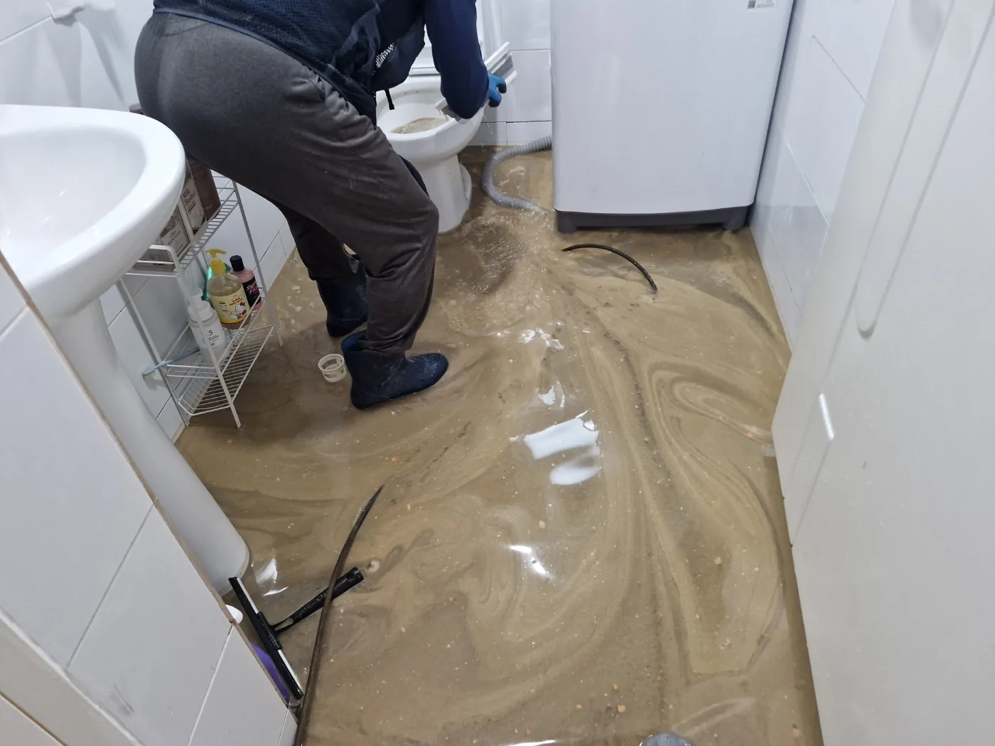 파주하수구역류 실제 현장에서 욕실 바닥으로 오수가 역류해 배관 작업을 진행하는 모습